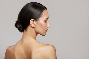 Beautiful brunette woman with low bun prom hairstyle